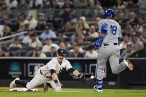 New York Yankees third baseman Jon Berti comes off the bag on a throwing error by third baseman Jazz Chisholm Jr. allowing Kansas City Royals’ Yuli Gurriel (18) to reach first base safely during the sixth inning of Game 2 of the American League baseball playoff series, Monday, Oct. 7, 2024, in New York.