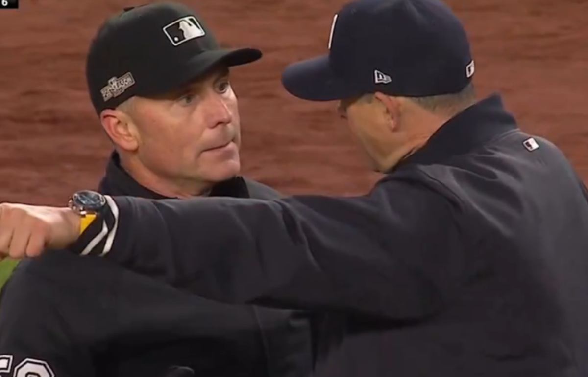 Umpire Mike Estabrook is seen in a discussion with Aaron Boone during a controversial moment in the seventh inning of the ALCS opener, where the Yankees secured a 5-2 victory over the Guardians on October 14, 2024.