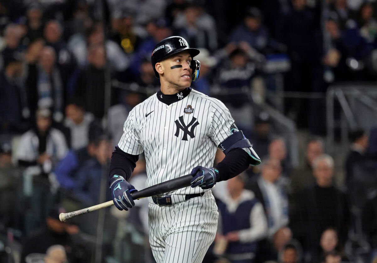 Aaron Judge caminando de vuelta al banquillo de los Yankees tras poncharse en la primera entrada el 28 de octubre de 2024, con expresión concentrada mientras agarra su bate, captada durante un partido crucial de postemporada.