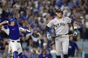 New York Yankees’ Aaron Judge, right, reacts after striking out as Los Angeles Dodgers catcher Will Smith throws the ball around the infield during the sixth inning in Game 2 of the baseball World Series, Saturday, Oct. 26, 2024, in Los Angeles.