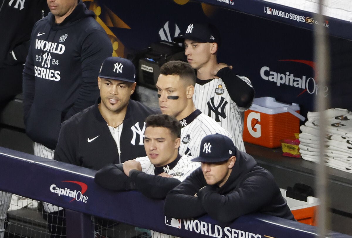 Giancarlo Stanton of the Yankees along with Aaron Judge, Anthony Volpe and DJ LeMahieu react on the dugout fence during the ninth inning.