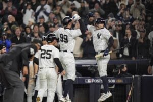 New York Yankees’ Aaron Judge (99) celebrates with Austin Wells after hitting a two-run home run against the Cleveland Guardians during the seventh inning in Game 2 of the baseball AL Championship Series Tuesday, Oct. 15, 2024, in New York.