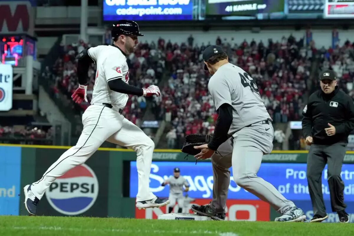 David Fry, a la izquierda, de los Guardianes de Cleveland, está a salvo en primera mientras el primera base de los Yankees de Nueva York, Anthony Rizzo, mira hacia atrás por un lanzamiento erróneo del lanzador Mark Leiter Jr. durante la octava entrada del cuarto partido de la Serie de Campeonato de la Liga Americana de Béisbol, el viernes 18 de octubre de 2024, en Cleveland.