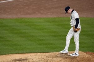 New York Yankees starting pitcher Clarke Schmidt waits for manager Aaron Boone to make his way to the mound to pull him during the third inning in Game 3 of the baseball World Series against the Los Angeles Dodgers, Monday, Oct. 28, 2024, in New York.