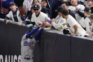 Fans interfere with a foul ball caught by Los Angeles Dodgers right fielder Mookie Betts during the first inning in Game 4 of the baseball World Series against the New York Yankees, Tuesday, Oct. 29, 2024, in New York.