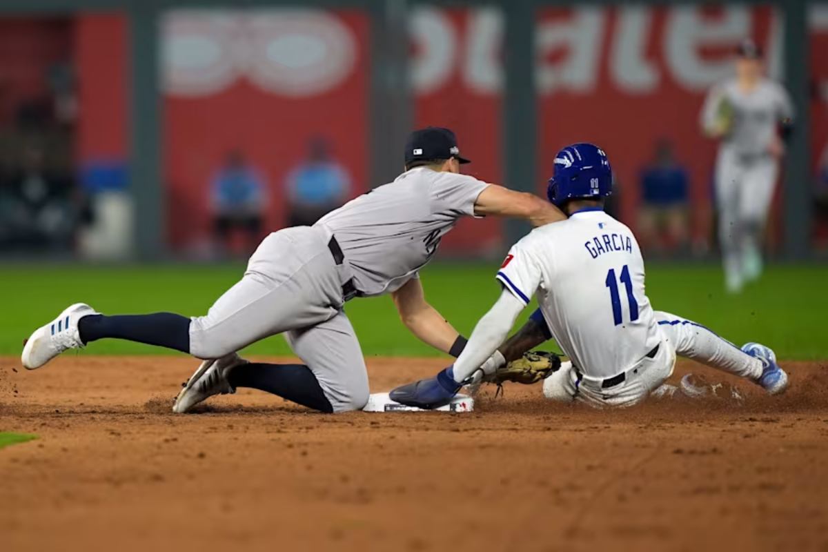 Anthony Volpe, campocorto de los Yankees de Nueva York, aplica una dura entrada a Maikel García, de los Reales de Kansas City, durante una doble jugada el 10 de octubre de 2024, lo que provocó tensiones que llevaron brevemente a que se despejaran los banquillos en la sexta entrada del cuarto partido de la Serie de División de la Liga Americana.