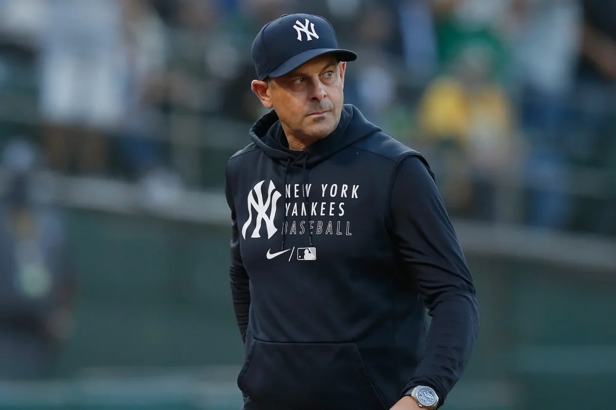 Yankees manager Aaron Boone stands in the dugout before an April 2024 game against the Red Sox.