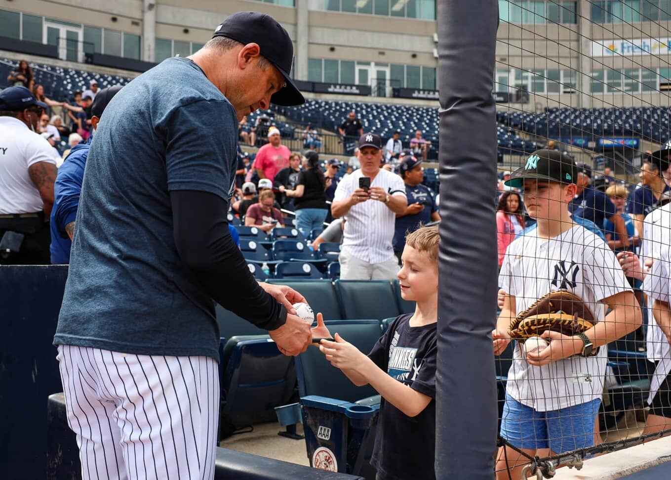 Yankees' manager Aaron Boone is with a young fan at Yankees spring training, Tampa, FL, on Feb. 16, 2025.