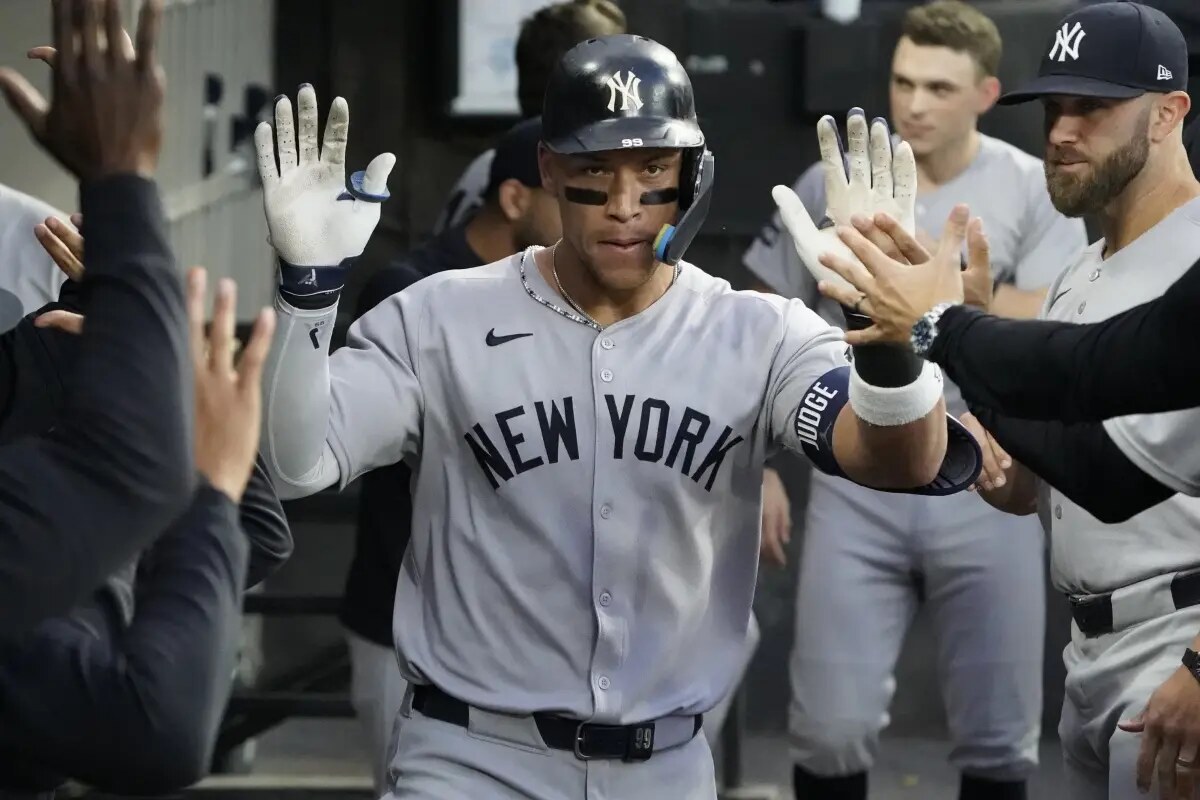 New York Yankees’ Aaron Judge, right, is greeted in the dugout after hitting a home run against the Chicago White Sox during the fourth inning of a baseball game Saturday, Aug. 30, 2025, in Chicago.