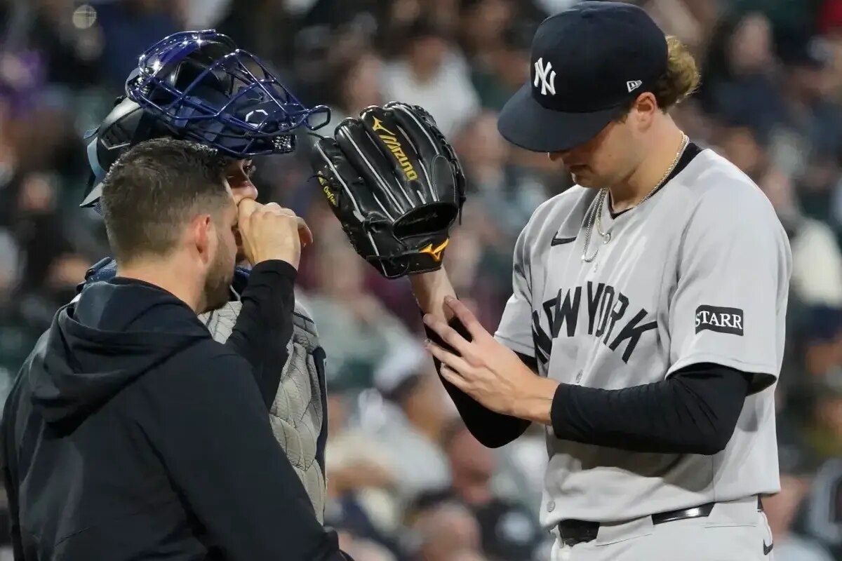 A trainer examines Cam Schlittler after he was struck with a ball during his Yankees start. 