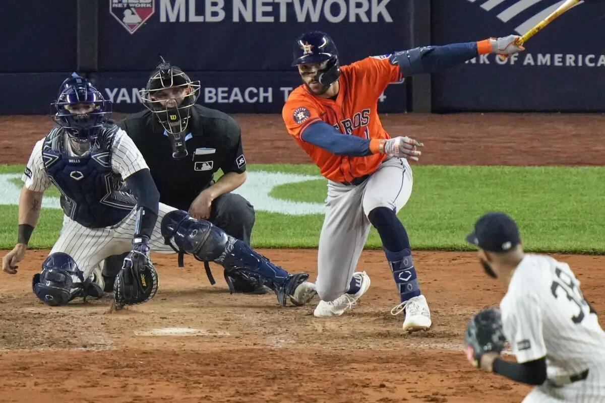 Houston Astros’ Carlos Correa (1) hits an RBI single during the 10th inning of a baseball game against the New York Yankees Friday, Aug. 8, 2025, in New York.