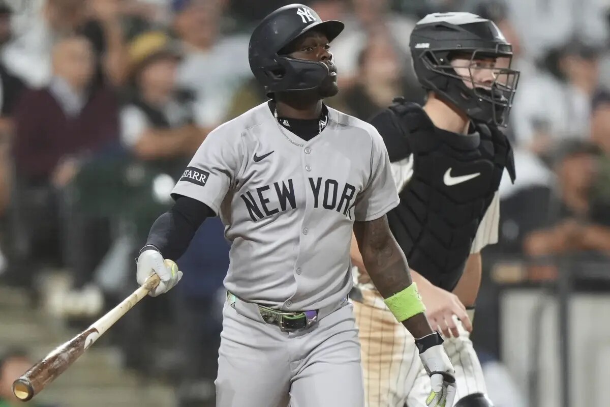New York Yankees’ Jazz Chisholm Jr., left, watches his sacrifice fly to Chicago White Sox right fielder Mike Tauchman during the fifth inning of a baseball game in Chicago, Thursday, Aug. 28, 2025.