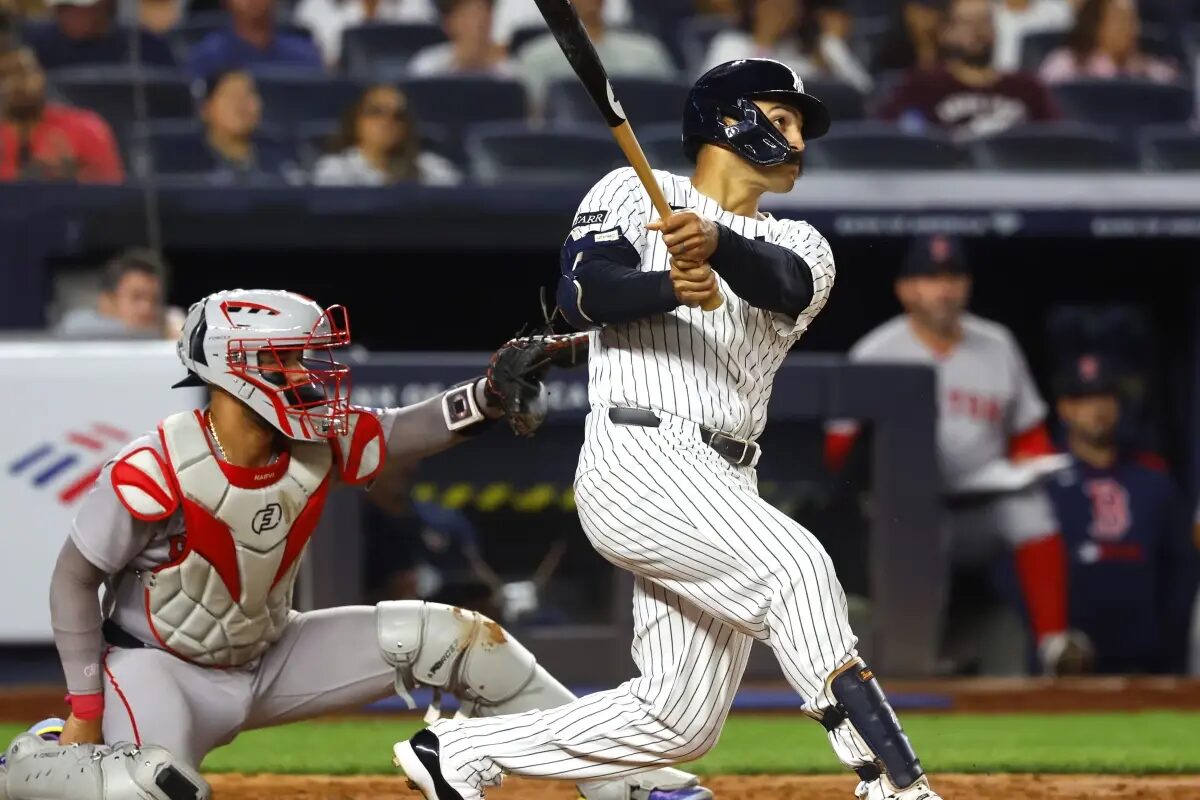 New York Yankees’ Trent Grisham, right, follows through on a home run during the fifth inning of a baseball game against the Boston Red Sox, Sunday, Aug. 24, 2025, in New York.