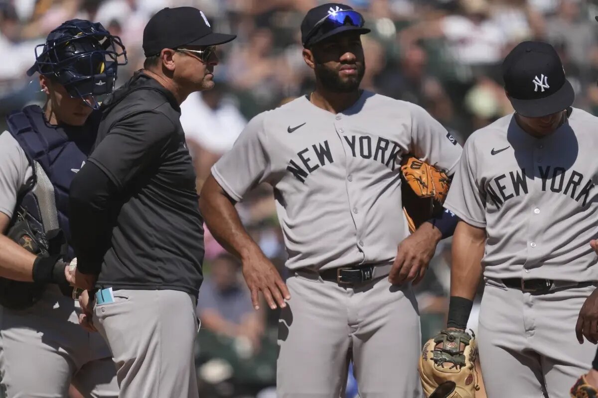 New York Yankees manager Aaron Boone, second from left, talks to players during the sixth inning of a baseball game against the Chicago White Sox in Chicago, Sunday, Aug. 31, 2025.