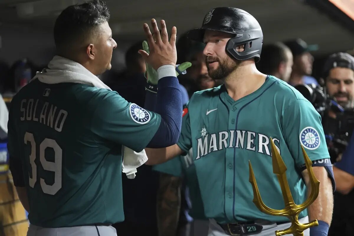 Seattle Mariners’ Cal Raleigh right, celebrates his grand slam with Donovan Solano (39) against the Detroit Tigers in the ninth inning during a baseball game, Friday, July 11, 2025, in Detroit.