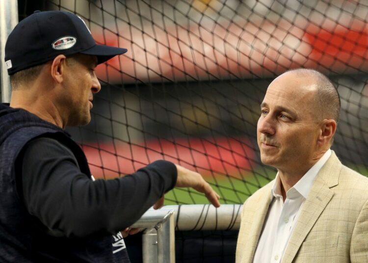 Yankees general manager Brian Cashman (right) is brining back manager Aaron Boone.