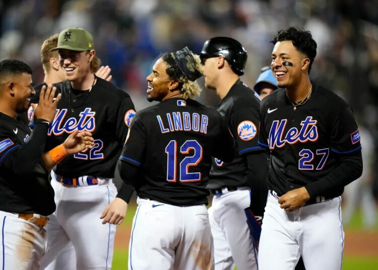 Francisco Lindor (c.) celebrates with teammates after hitting a walkoff RBI-single on Friday night.
