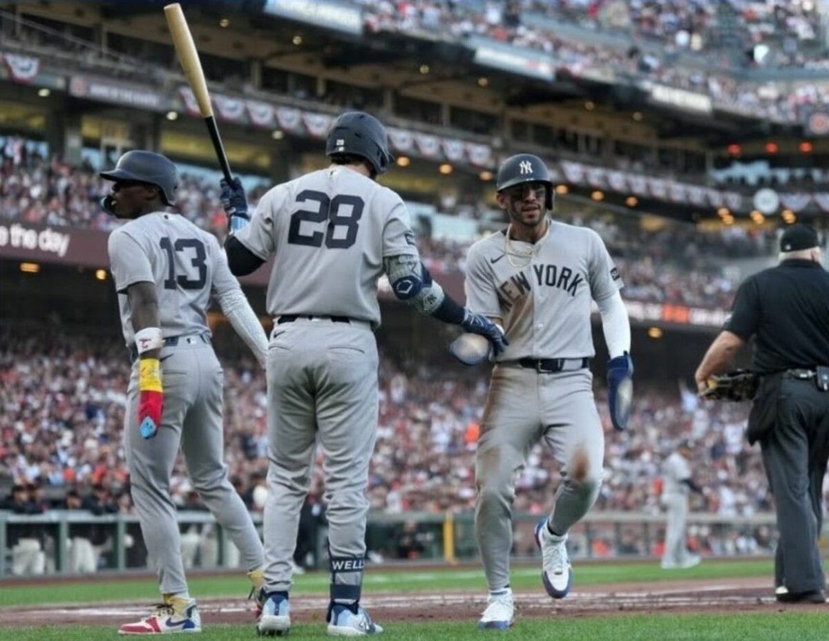 Jazz Chisholm Jr. Jose Caballero, and Austin Wells celebrate after a run during the Yankees' 7-0 win over the Giants in San Francisco, March 25, 2026.