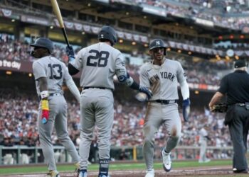 Jazz Chisholm Jr. Jose Caballero, and Austin Wells celebrate after a run during the Yankees' 7-0 win over the Giants in San Francisco, March 25, 2026.