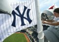 A worker puts a Yankees flag on a pole in Yankee Stadium, 2026.
