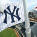 A worker puts a Yankees flag on a pole in Yankee Stadium, 2026.