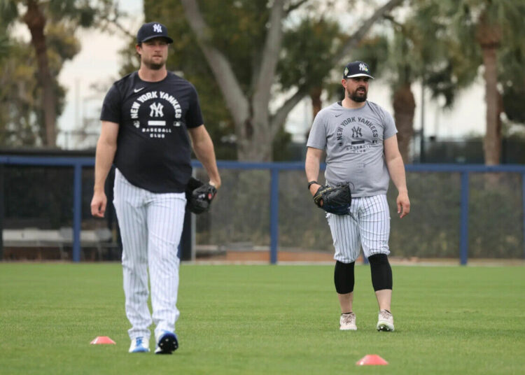 Yankees pitcher Gerrit Cole #45, (left) and New York Yankees pitcher Carlos Rodón #55, throwing on a back field as pitchers and catchers reported to Spring Training.