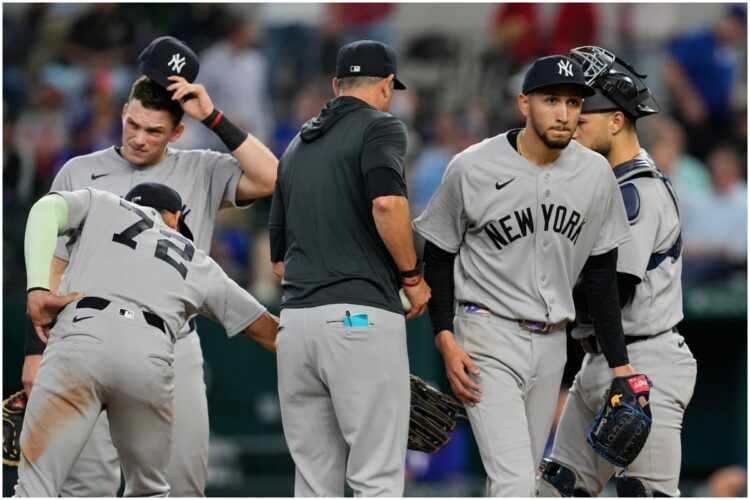 New York Yankees starting pitcher Elmer Rodriguez, right front, walks to the dugout after turning the ball over to manager Aaron Boone, center left, as José Caballero (72), Ben Rice, left rear, and J.C. Escarra, right rear, stand on the mound in the fifth inning of a baseball game against the Texas Rangers Wednesday, April 29, 2026, in Arlington, Texas.