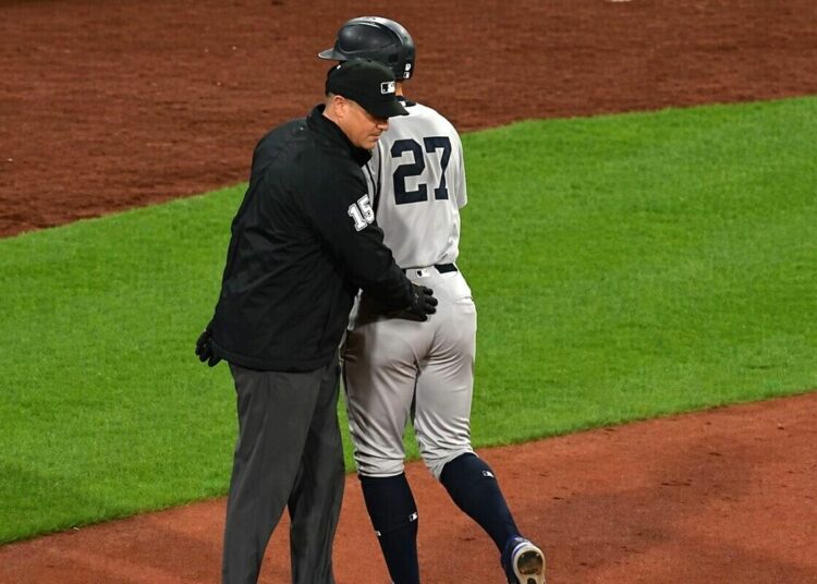 Umpire pats on Giancarlo Stanton after his homer in the Yankees' 4-0 win over the Red Sox in Boston, Apr. 21, 2026.