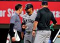 New York Yankees’ Jasson Dominguez, center, talks with a team trainer as manager Aaron Boone, right, looks on after Dominguez was hit by a pitch in the fourth inning of a baseball game against the Texas Rangers Wednesday, April 29, 2026, in Arlington, Texas.