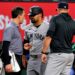 New York Yankees’ Jasson Dominguez, center, talks with a team trainer as manager Aaron Boone, right, looks on after Dominguez was hit by a pitch in the fourth inning of a baseball game against the Texas Rangers Wednesday, April 29, 2026, in Arlington, Texas.
