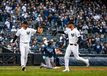 Yankees' Ryan McMahon and Cody Bellinger celebrate after throwing Rays' Junior Caminero at third base in New York’s 2-0 win on May 24, 2026.