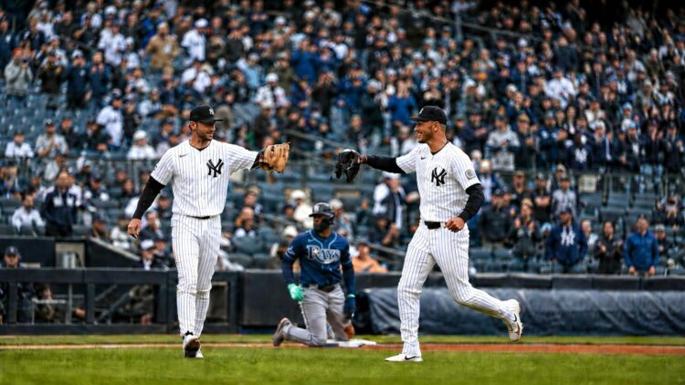 Yankees' Ryan McMahon and Cody Bellinger celebrate after throwing Rays' Junior Caminero at third base in New York’s 2-0 win on May 24, 2026.