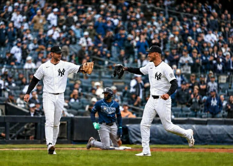 Yankees' Ryan McMahon and Cody Bellinger celebrate after throwing Rays' Junior Caminero at third base in New York’s 2-0 win on May 24, 2026.