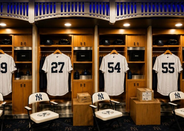 An image of the Yankees clubhouse at New York's Yankee Stadium with Judge, Fried, Rodon, and Stanton jerseys, 2026.