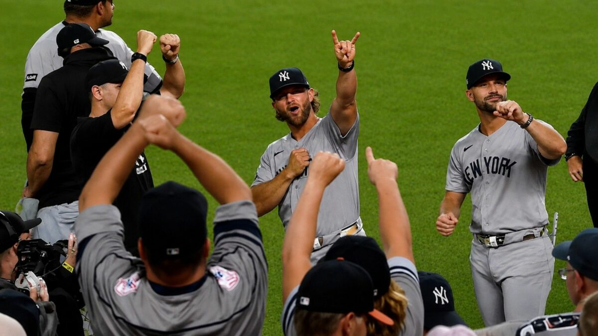 Manager Aaron Boone and coaches celebrated with fans after the Yankees' 5-3 win over the Orioles, Baltimore, August 19, 2026.