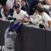 Fans interfere with a foul ball caught by Los Angeles Dodgers right fielder Mookie Betts during the first inning in Game 4 of the baseball World Series against the New York Yankees, Tuesday, Oct. 29, 2024, in New York.